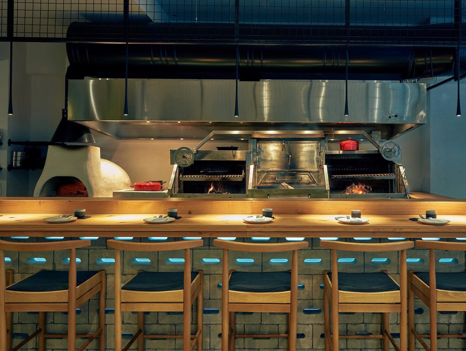 The Maestranza open kitchen — bar counter, wood-fire grills and stone oven